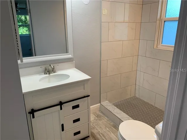 a bathroom with a sink toilet and shower