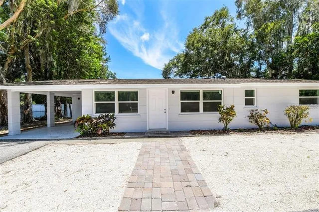 a view of house with backyard and sitting area