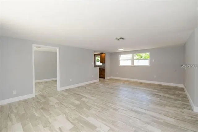 an empty room with windows and mirror