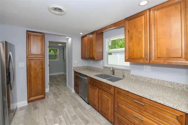 a kitchen with stainless steel appliances granite countertop a refrigerator and a sink