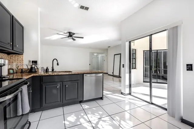 a kitchen with stainless steel appliances granite countertop a refrigerator and a sink