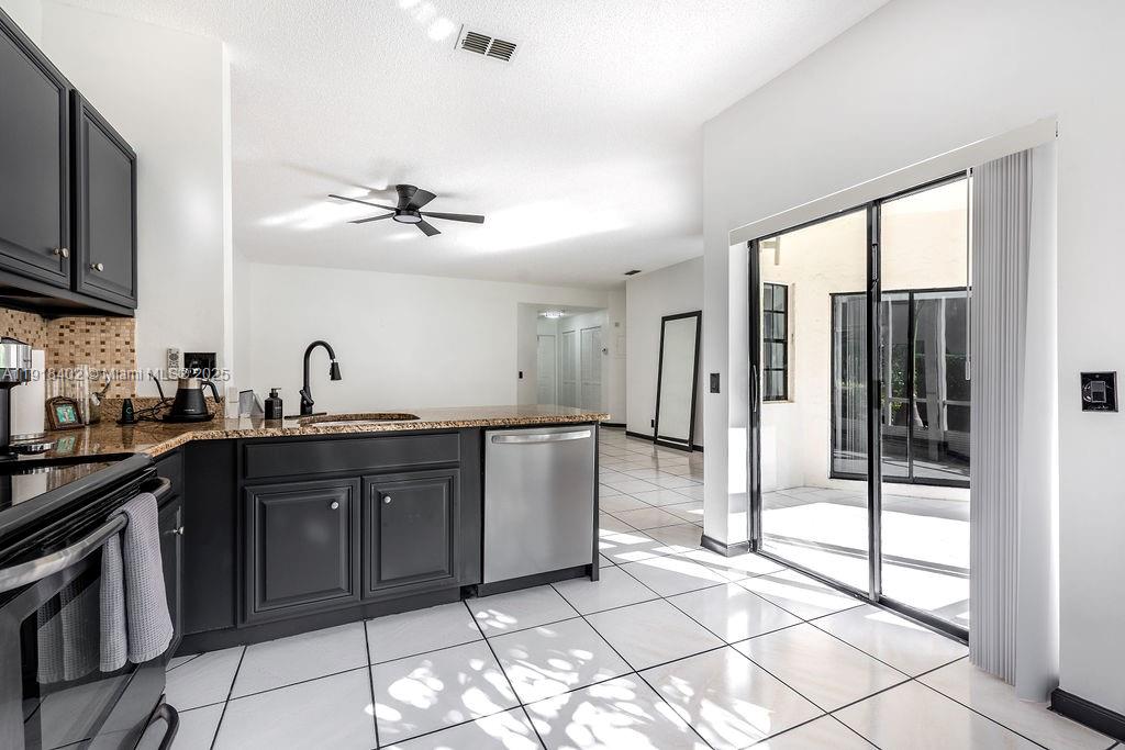 a kitchen with stainless steel appliances granite countertop a refrigerator and a sink