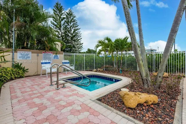 a view of a patio with table and chairs under an umbrella