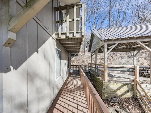a backyard of a house with large trees and wooden fence