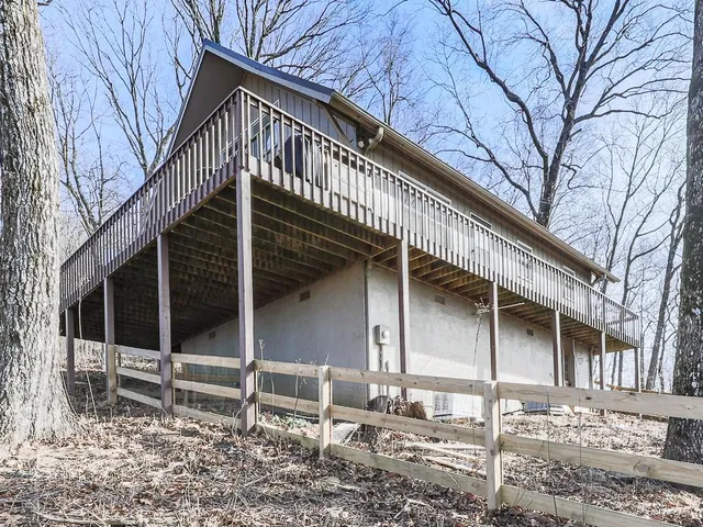 a view of a house with wooden fence and floor to ceiling window