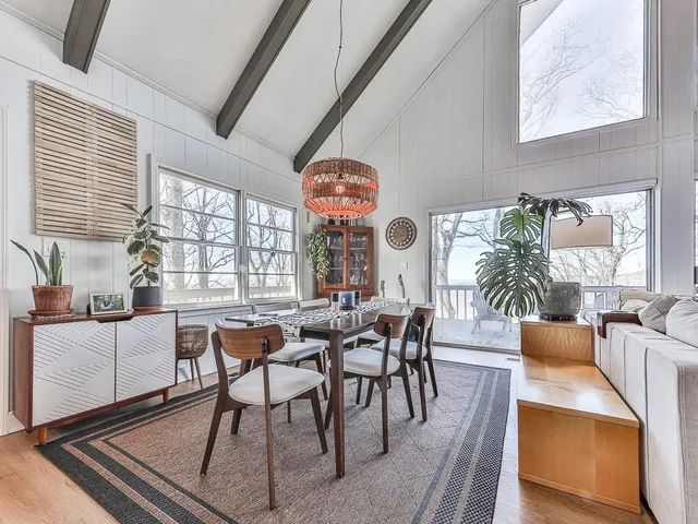 a dining room with furniture a chandelier and wooden floor