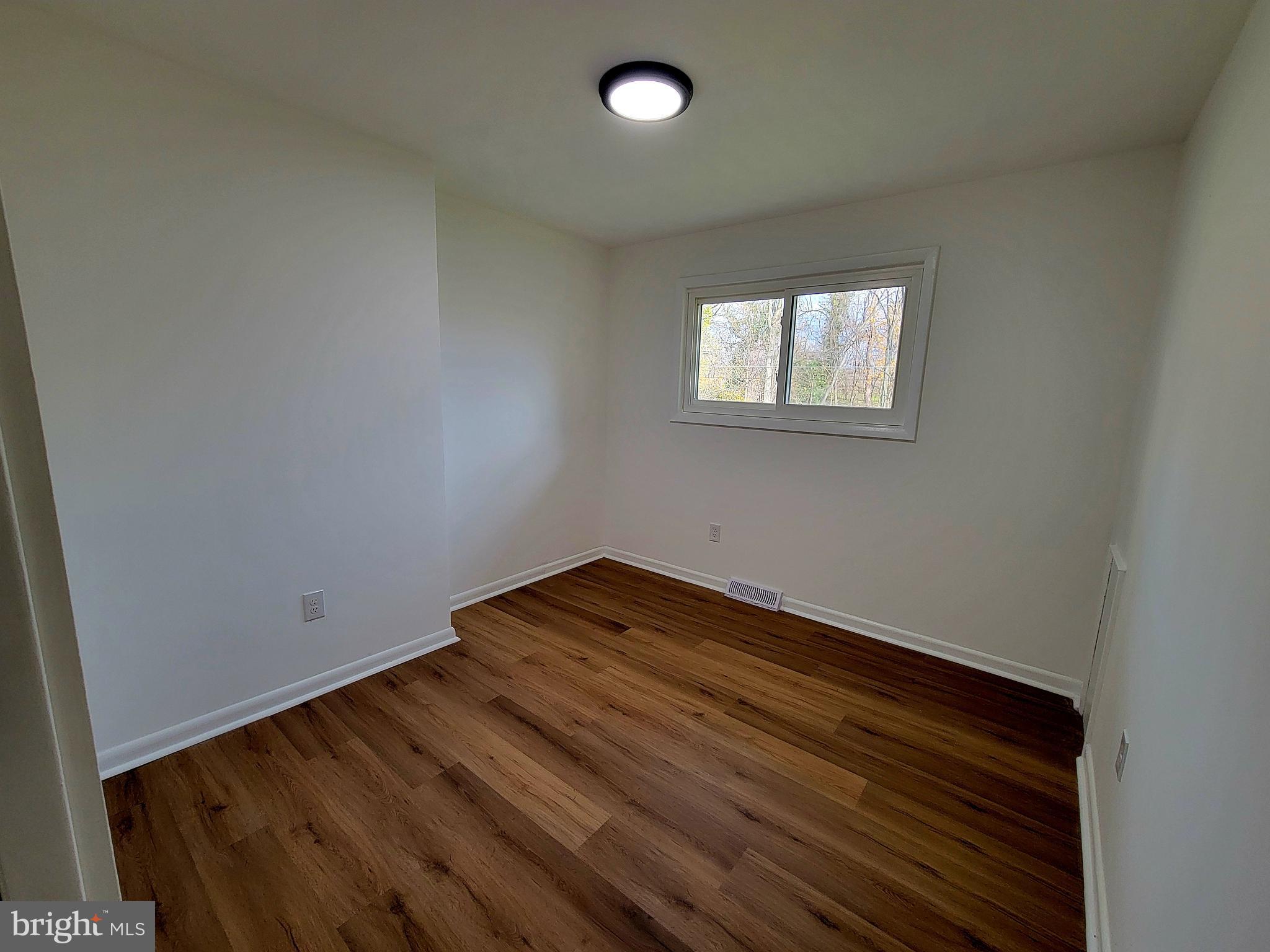 11525 Englewood Road Hagerstown, MD 21740 - Photo 9 of 21 an empty room with wooden floor and windows