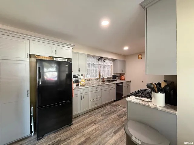 a kitchen with a refrigerator a stove a sink and cabinets