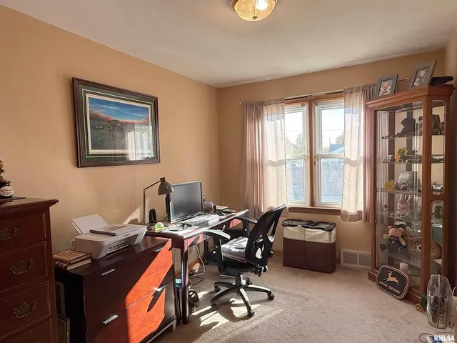 a view of a workspace with furniture and a window
