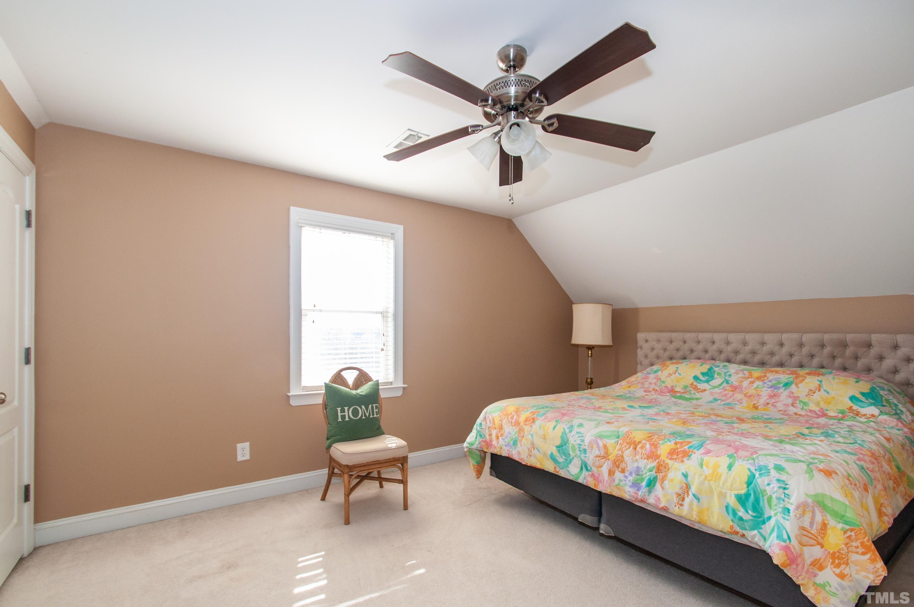 5012 Contender Drive Raleigh, NC 27603 - Photo 14 of 27 a bedroom with a bed a chair and a large window