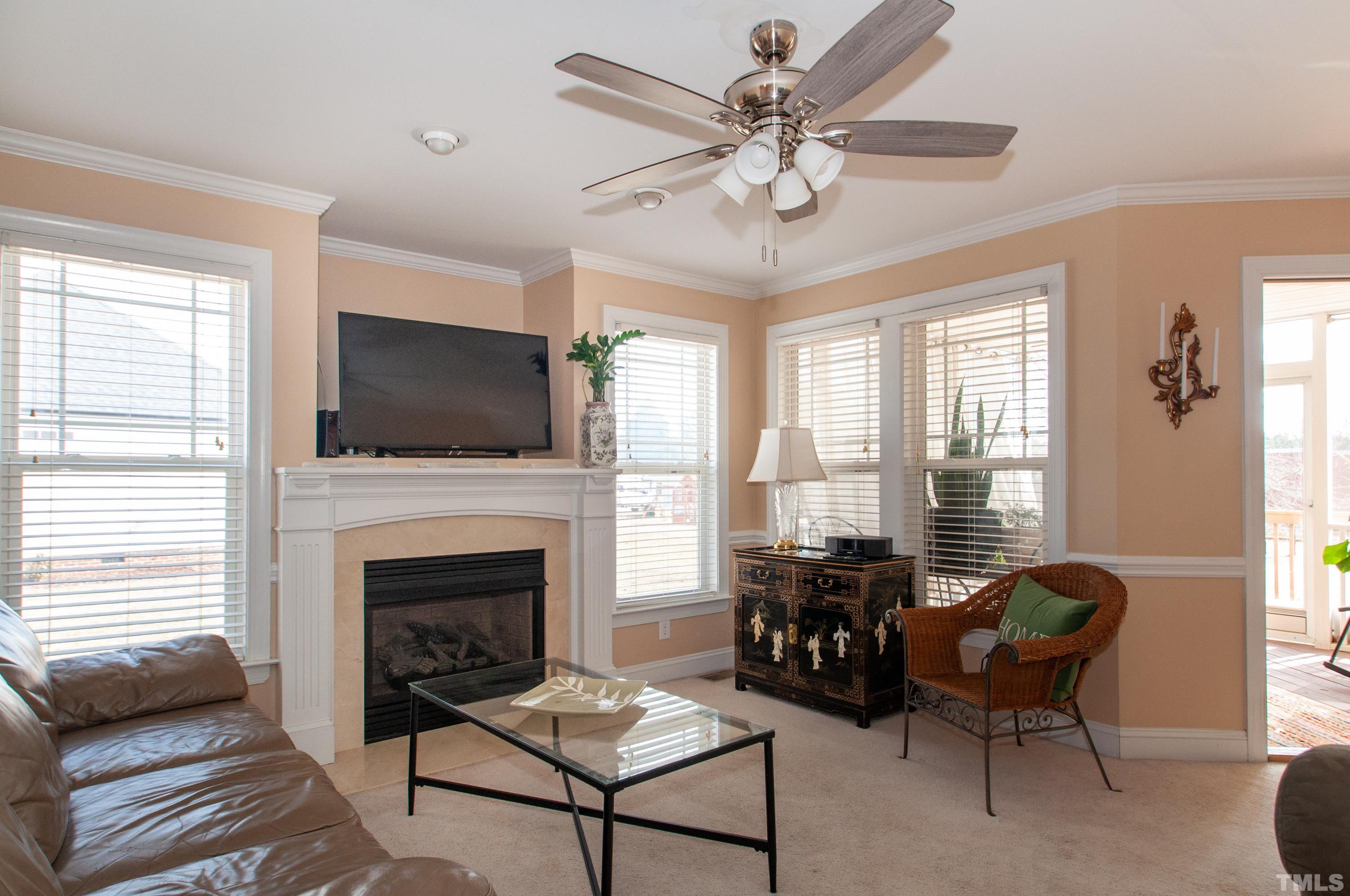 5012 Contender Drive Raleigh, NC 27603 - Photo 4 of 27 a living room with furniture a flat screen tv and a fireplace