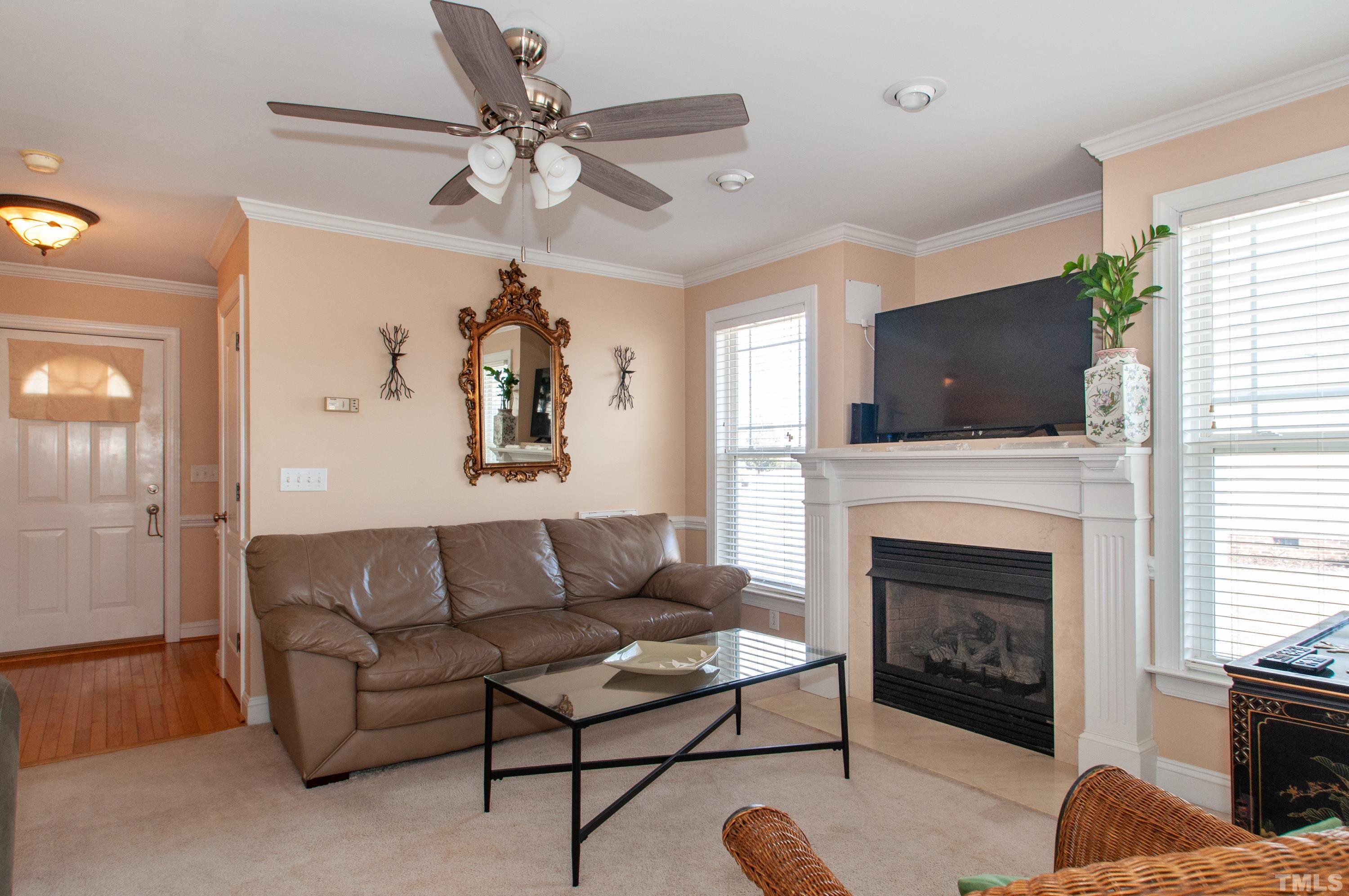 5012 Contender Drive Raleigh, NC 27603 - Photo 5 of 27 a living room with furniture a fireplace and a flat screen tv