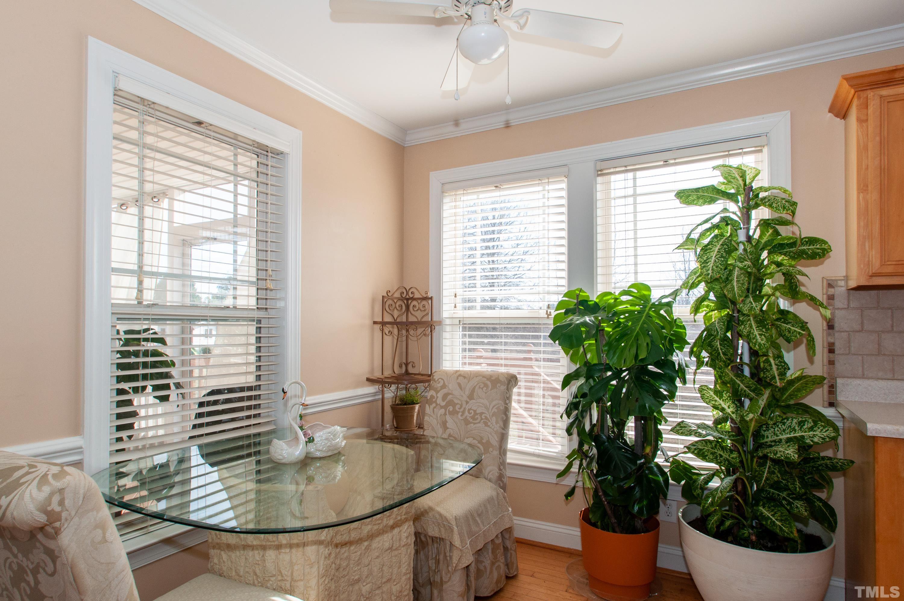 5012 Contender Drive Raleigh, NC 27603 - Photo 9 of 27 a dining room with furniture potted plants and wooden floor