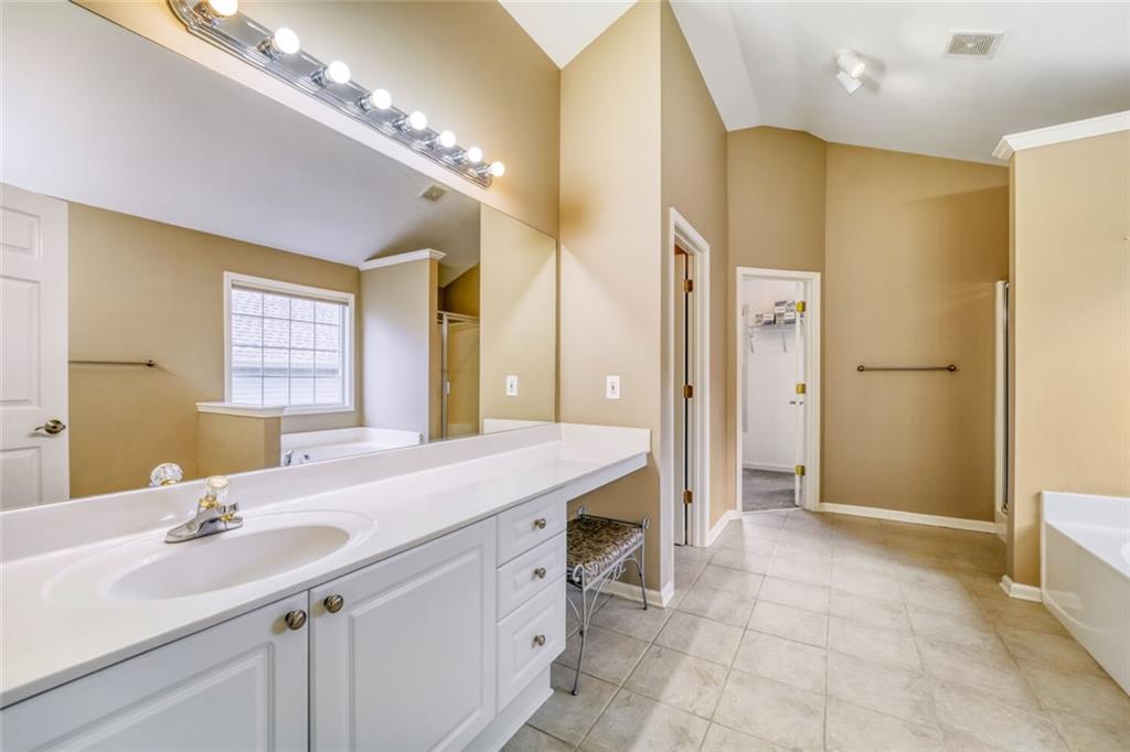 2531 Apalachee Run Way Dacula, GA 30019 - Photo 18 of 29 a bathroom with a granite countertop sink a large mirror and a shower