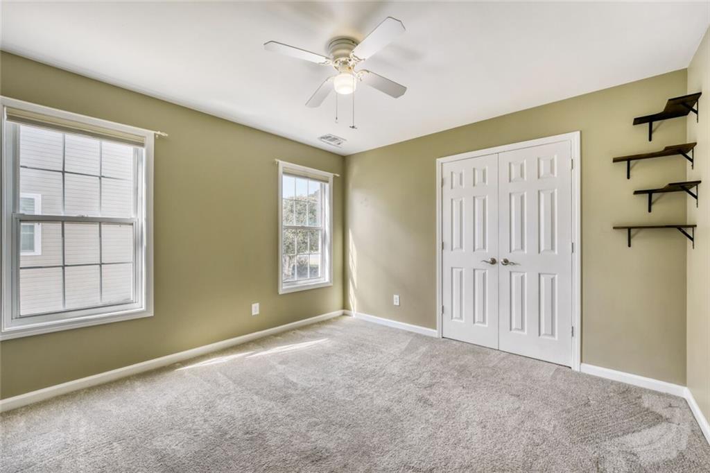 2531 Apalachee Run Way Dacula, GA 30019 - Photo 20 of 29 an empty room with windows and ceiling fan