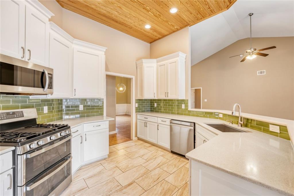 2531 Apalachee Run Way Dacula, GA 30019 - Photo 10 of 29 a kitchen with a stove a sink and a refrigerator