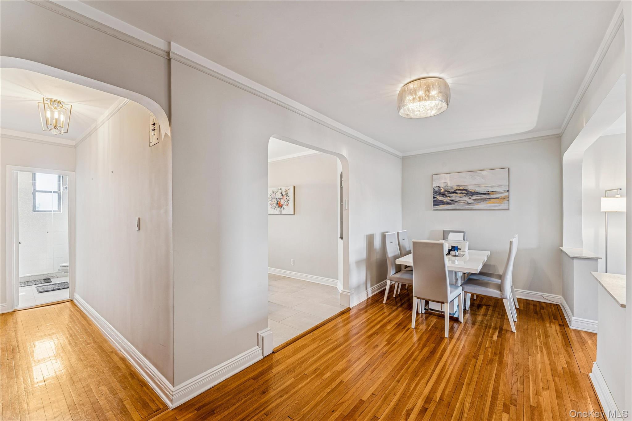 84-51 Beverly Road, Unit 6R Queens, NY 11415 - Photo 5 of 19 a dining room with wooden floor and stainless steel appliances