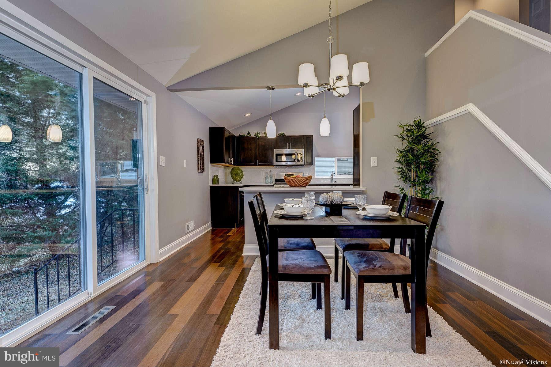 835 Milford Mill Road Baltimore, MD 21208 - Photo 11 of 30 a dining room with wooden floor a chandelier a wooden table and chairs