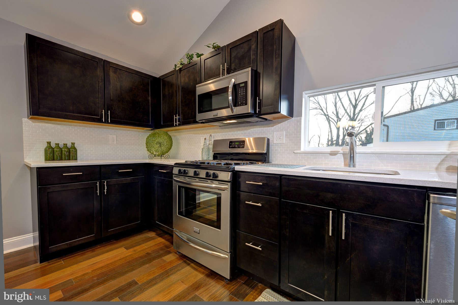 835 Milford Mill Road Baltimore, MD 21208 - Photo 14 of 30 a kitchen with stainless steel appliances a stove a sink a microwave and cabinets