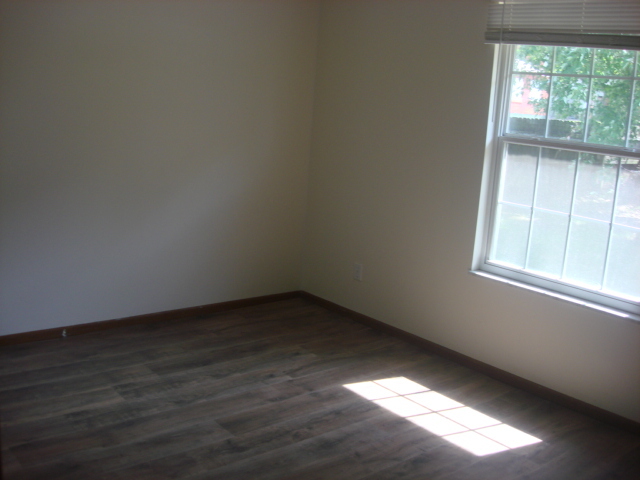 601 Catlin Street Ottawa, IL 61350 - Photo 9 of 29 an empty room with wooden floor and windows in it