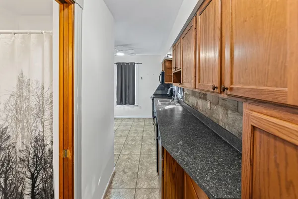 a large kitchen with granite countertop a sink and a large window