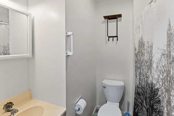 a white toilet sitting next to a bathroom sink and vanity