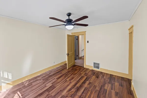 a view of room with hardwood floor and a ceiling fan