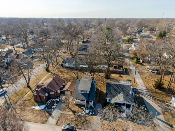 an aerial view of a house with a yard and wooden fence