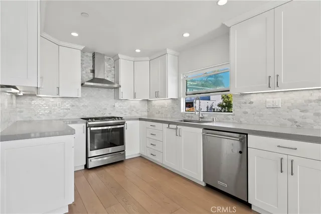 a kitchen with granite countertop white cabinets white stainless steel appliances with a sink and dishwasher