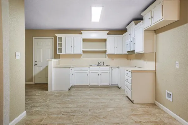 a kitchen with cabinets stainless steel appliances a sink and a window