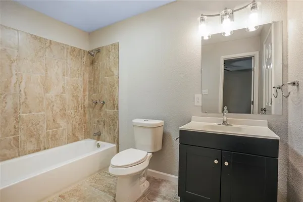 a bathroom with a sink a toilet a mirror a vanity and bathtub