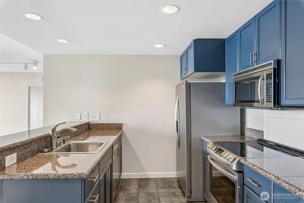 a kitchen that has a sink cabinets counter space and stainless steel appliances