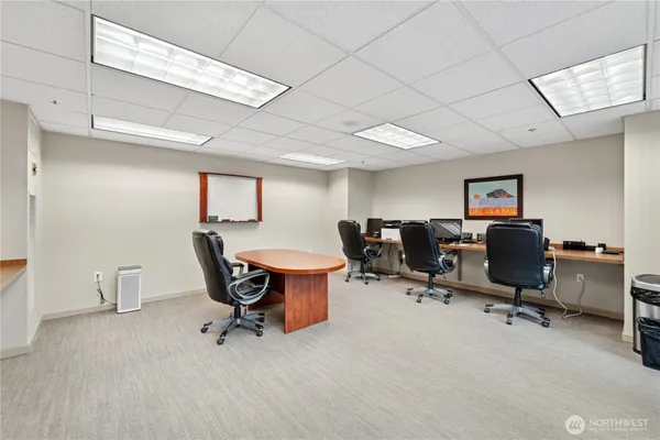 a view of a workspace with furniture and a window