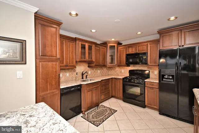 a kitchen with granite countertop a sink stove and cabinets