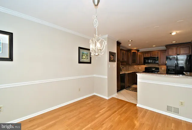 a view of a livingroom with a fireplace a ceiling fan and wooden floor