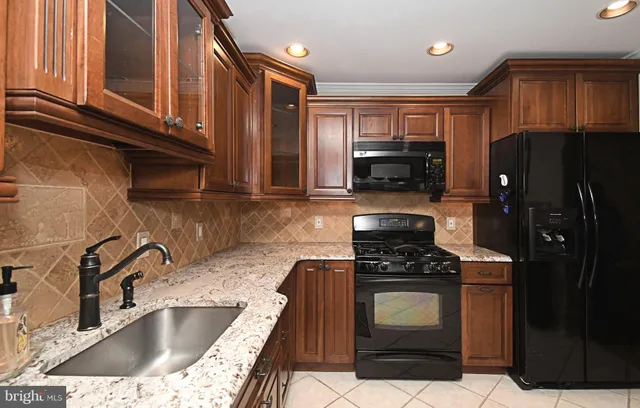 a kitchen with stainless steel appliances granite countertop a sink stove top oven and cabinets
