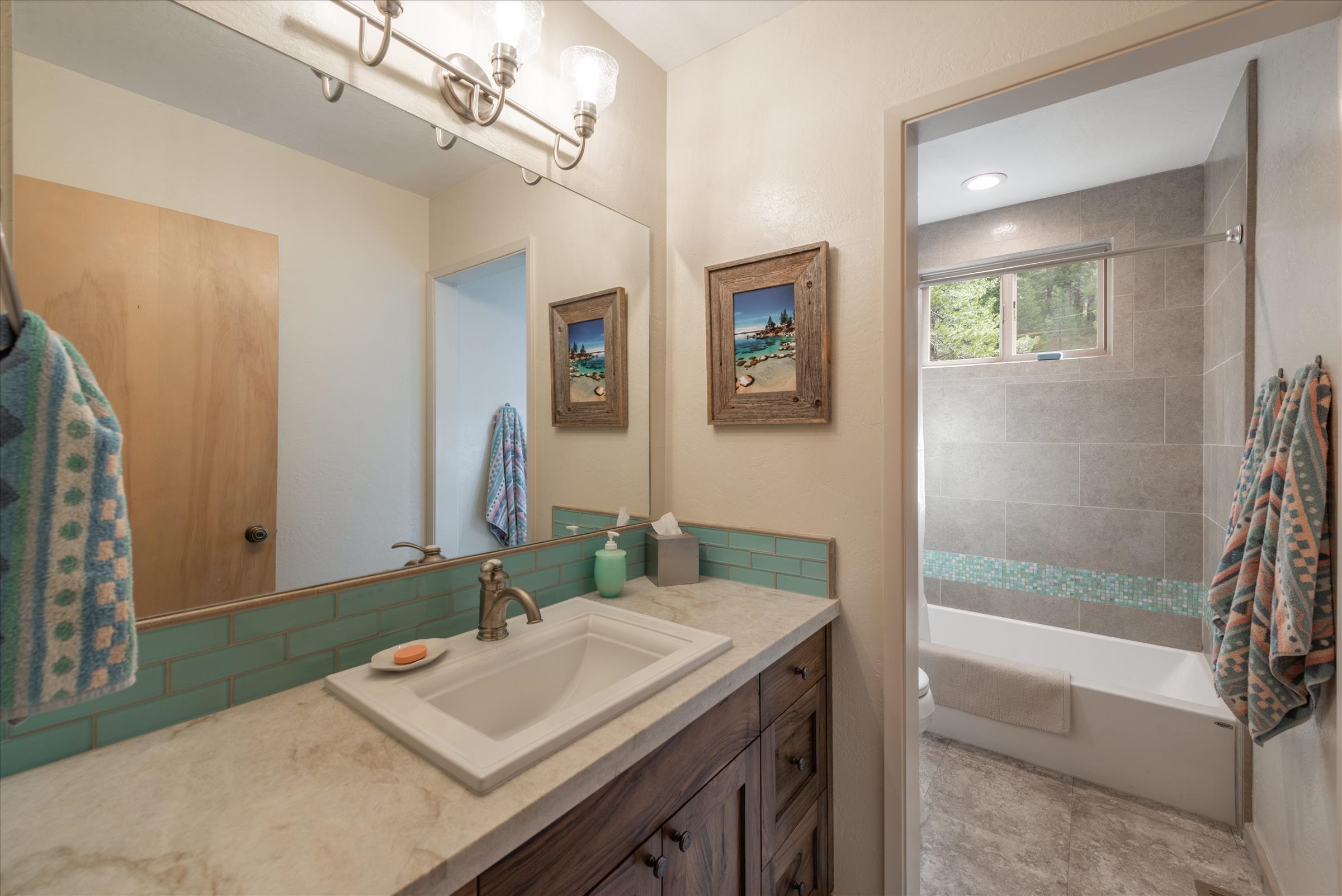 6860 River Road Truckee, CA 96161 - Photo 15 of 21 a bathroom with a sink a large mirror and a bathtub