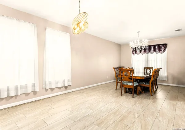 a view of a dining room with furniture and a chandelier