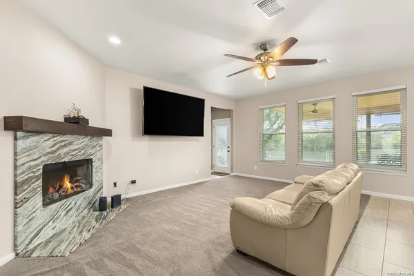 a living room with furniture a flat screen tv and a fireplace