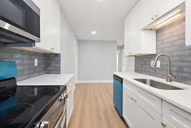 a kitchen with sink stove and cabinets