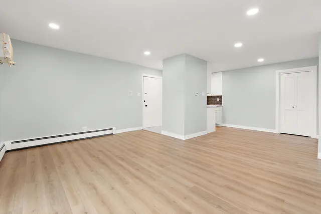 a view of empty room with wooden floor