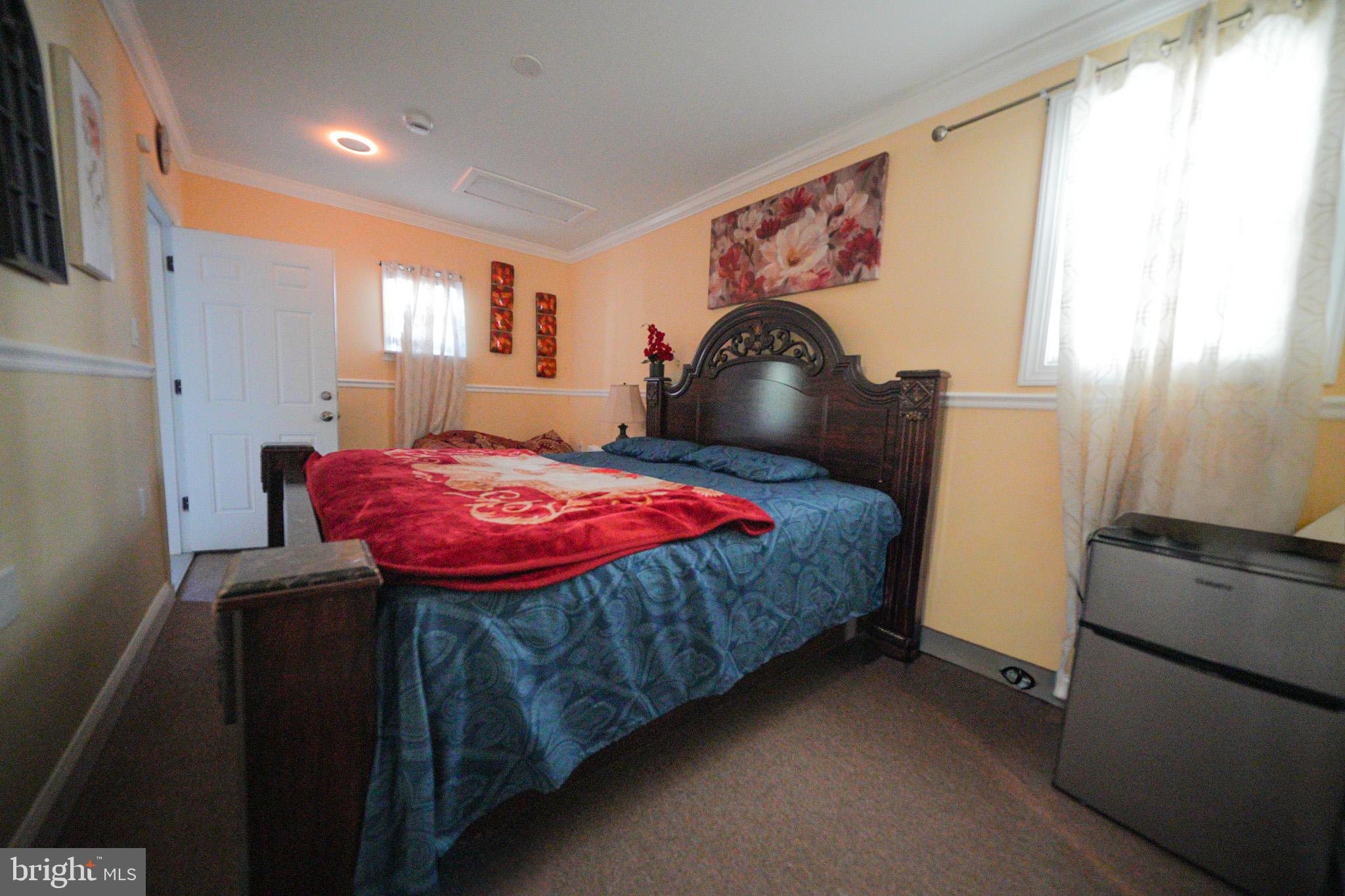 2001 Denison Street Baltimore, MD 21216 - Photo 16 of 43 a bedroom with a bed and a dresser next to a window