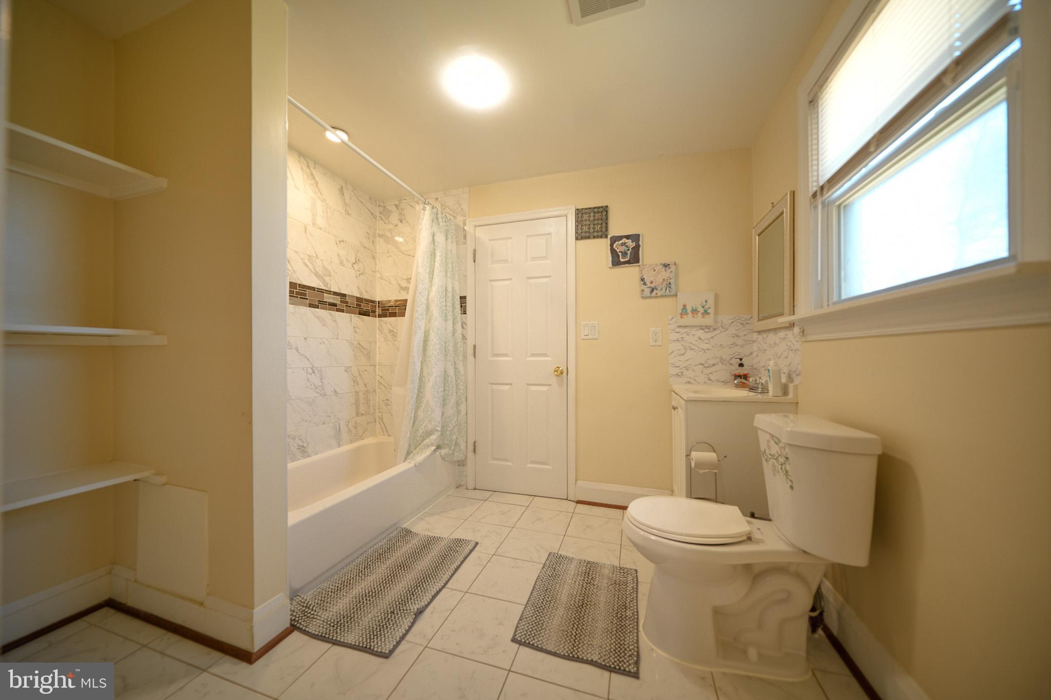 2001 Denison Street Baltimore, MD 21216 - Photo 17 of 43 a bathroom with a granite countertop toilet a sink and shower