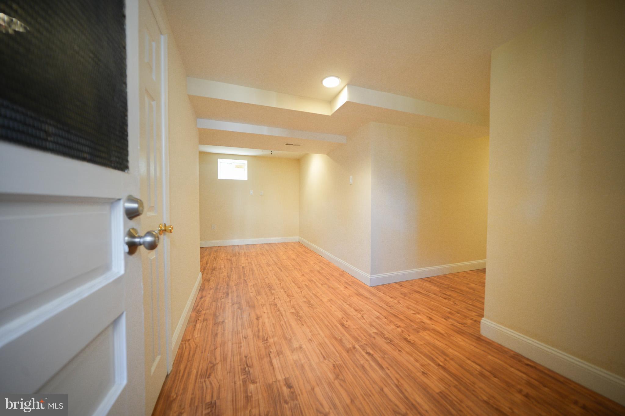 2001 Denison Street Baltimore, MD 21216 - Photo 34 of 43 a view of a room with wooden floor and a flat screen tv