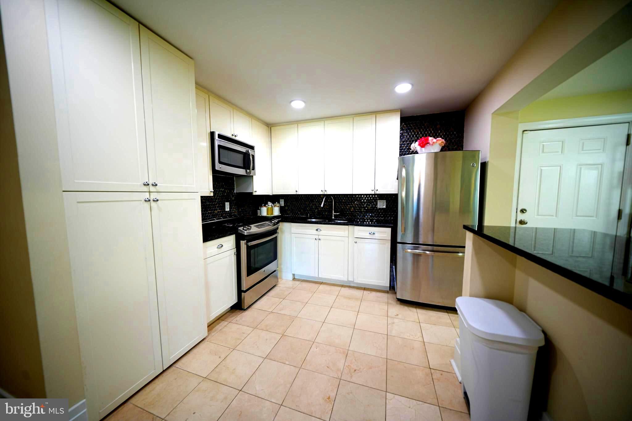 2001 Denison Street Baltimore, MD 21216 - Photo 10 of 43 a kitchen with a refrigerator a microwave a sink and a stove