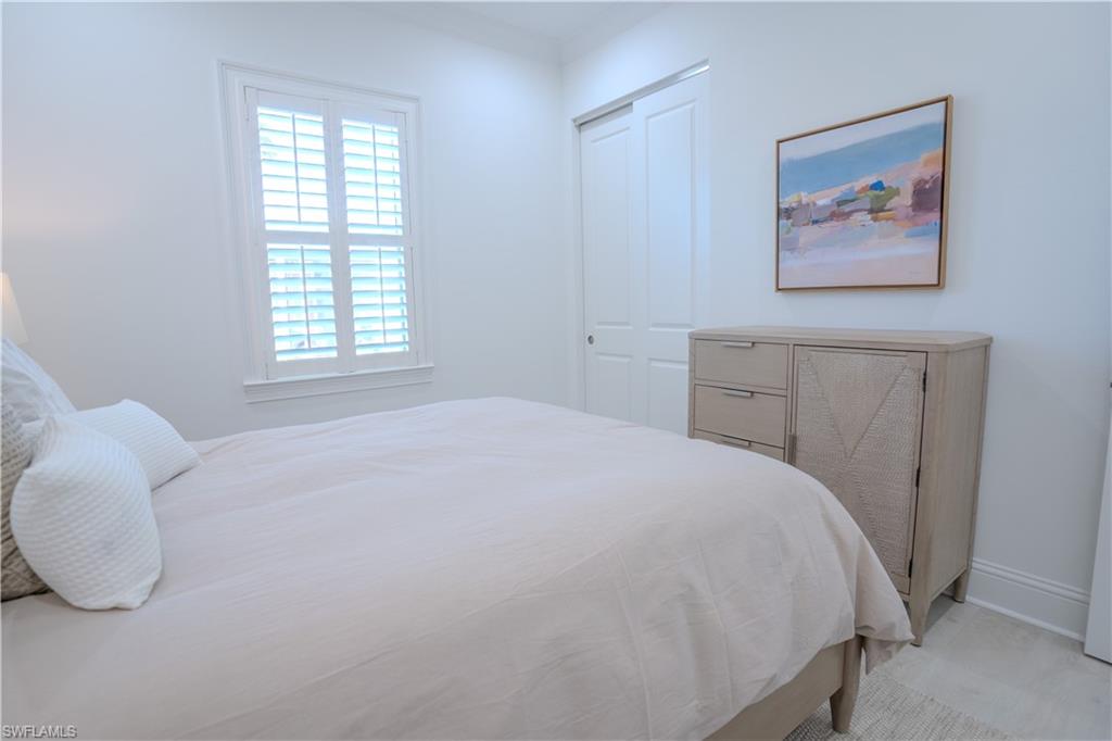7150 Saona Court Naples, FL 34113 - Photo 10 of 31 a bedroom with a bed and a painting on the wall