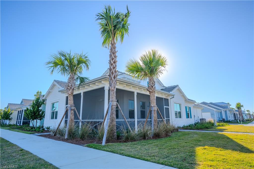 7150 Saona Court Naples, FL 34113 - Photo 18 of 31 a front view of a house with a garden and yard