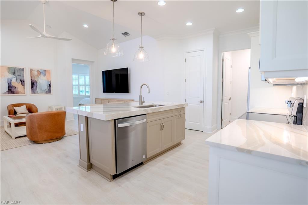 7150 Saona Court Naples, FL 34113 - Photo 30 of 31 a large white kitchen with kitchen island a sink stainless steel appliances and cabinets