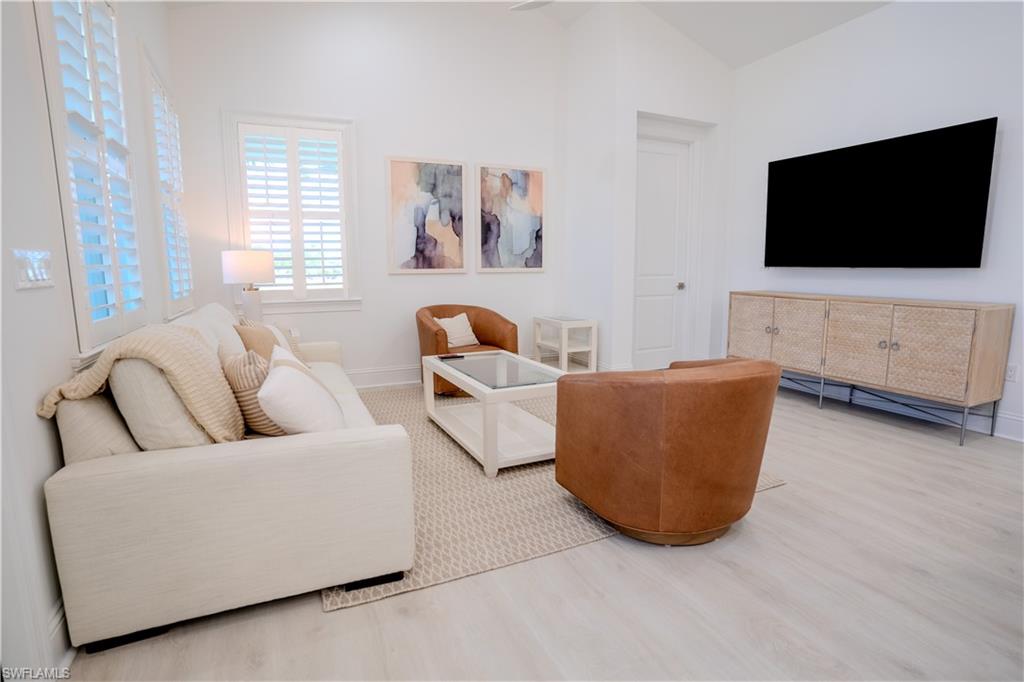 7150 Saona Court Naples, FL 34113 - Photo 2 of 31 a living room with furniture and a flat screen tv