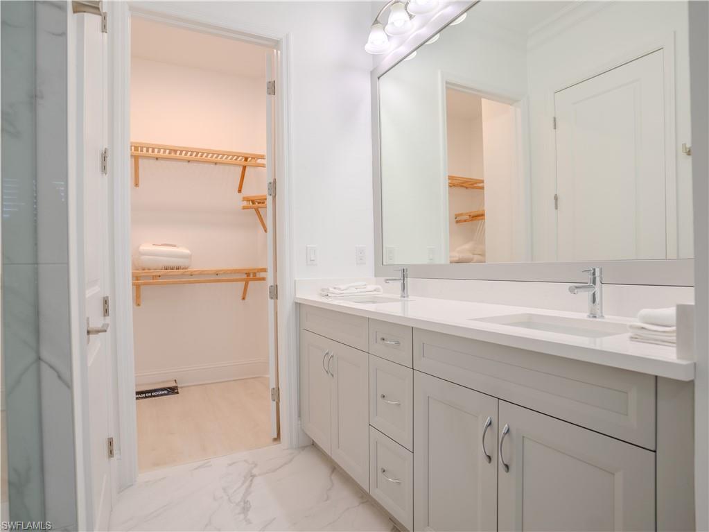 7150 Saona Court Naples, FL 34113 - Photo 7 of 31 a bathroom with a double vanity sink and a mirror